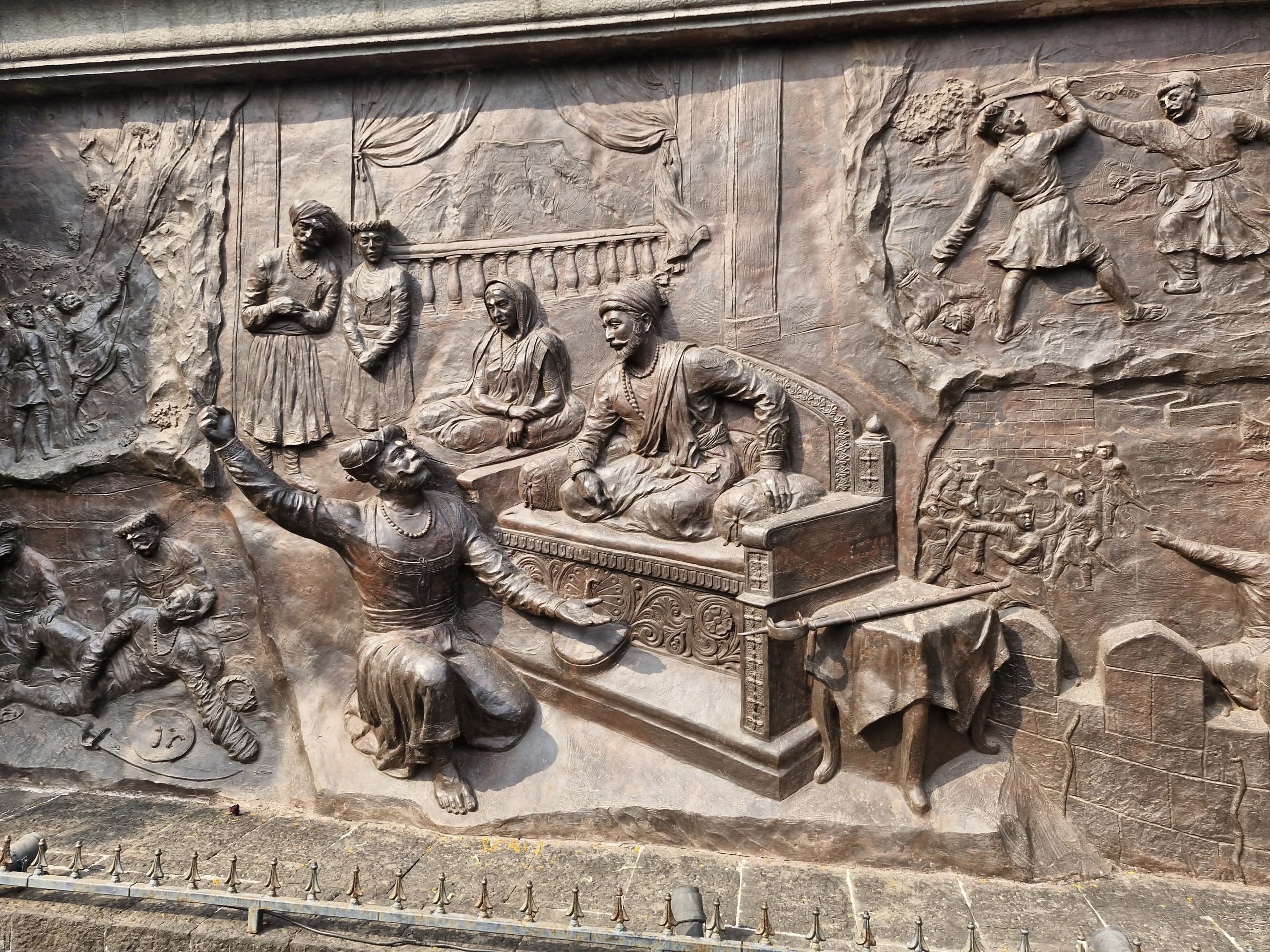 Bronze relief mural at Sinhagad Fort showing Chhatrapati Shivaji Maharaj holding court while the battle for the fort unfolds around the durbar.